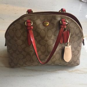 Coach handbag with red lining and strap